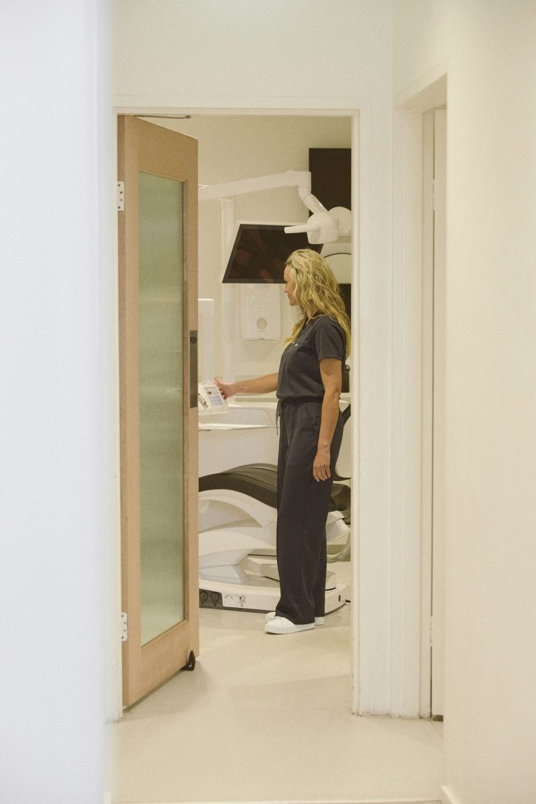 A dentist at the door of a treatment room at Dental Collective Rose Bay